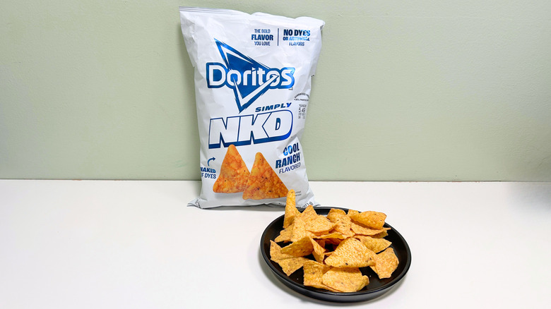 A bag of Doritos Simply NKD Cool Ranch next to a black plate of chips