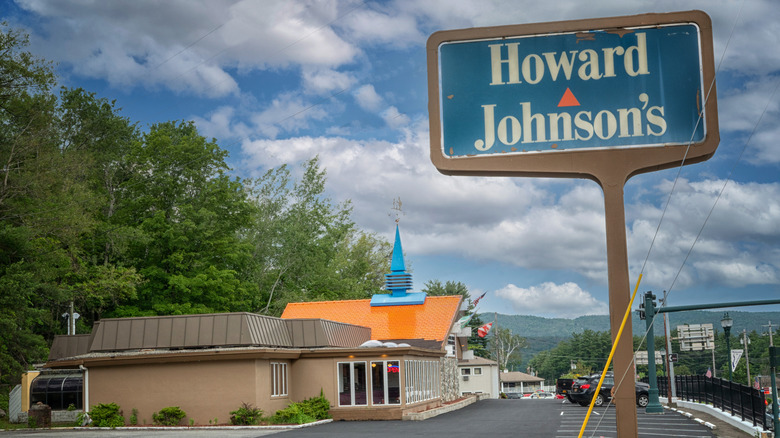 A view of a Howard Johnson's restaurant, with the road sign visible in the foreground, and the restaurant in the background