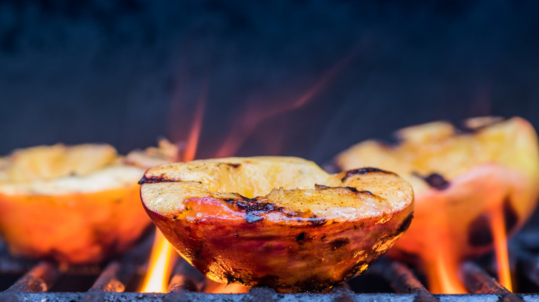 Halved peaches cooked over a flame