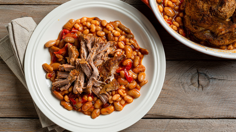 A plate of baked beans topped with pulled pork