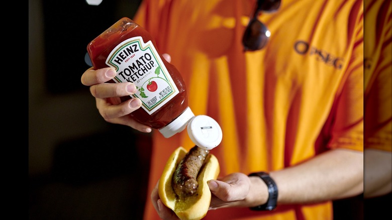 Pouring ketchup on sausage