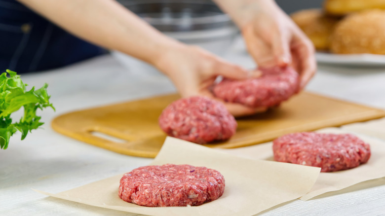 Raw hamburger patties on parchment paper