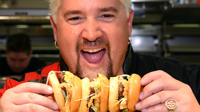 Guy Fieri holding burgers
