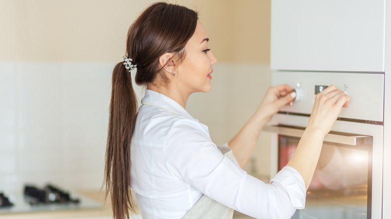 Woman turning on broiler
