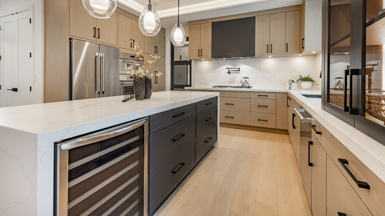 Bright kitchen with white countertops and black and natural wood cabinets
