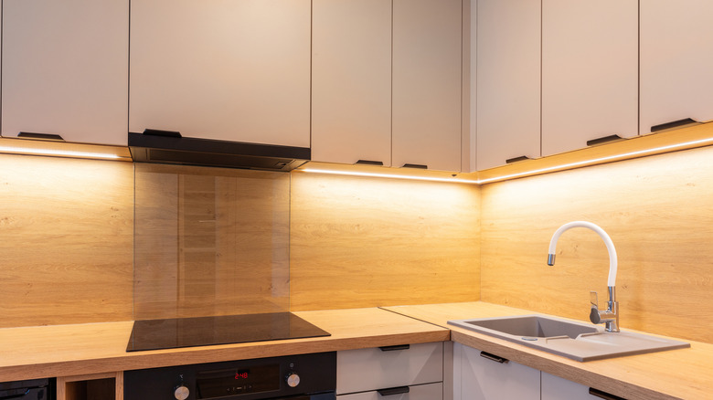 Neutral upper cabinets in kitchen with lights underneath