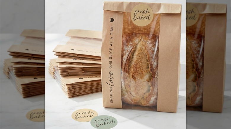 Bread in printed bag next to stack of more bags