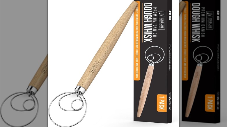 Danish whisk with wood handle next to box