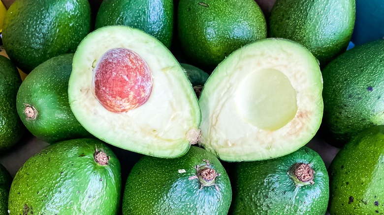 fuerte sliced open on top of more avocados
