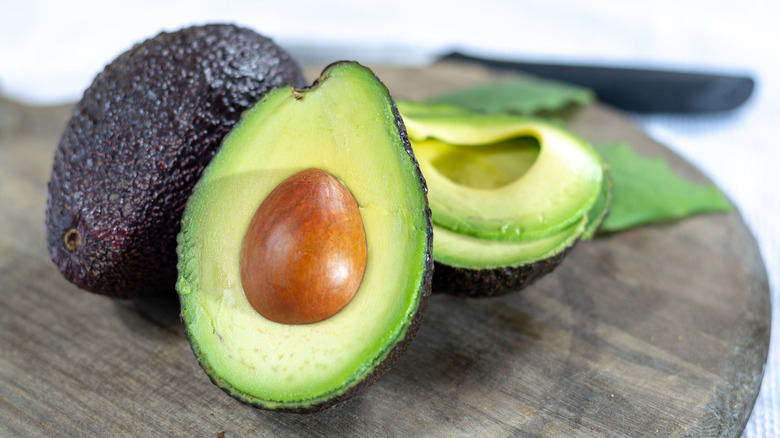 halved Hass avocado close-up on wood