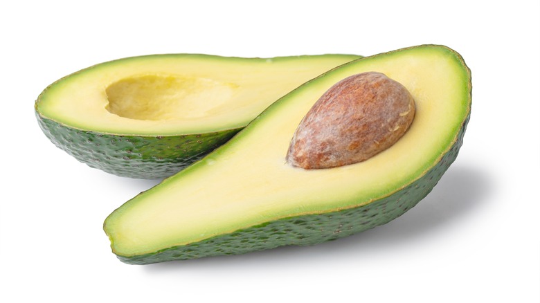 halved avocado on white background