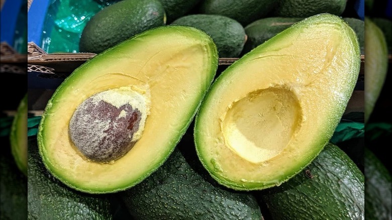 avocado halved sitting on other avos