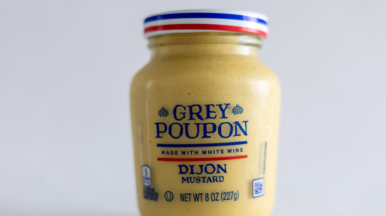 A small bottle of Grey Poupon Dijon mustard
