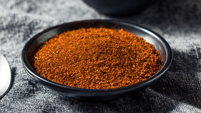 Reddish-brown smoked paprika in a small black bowl