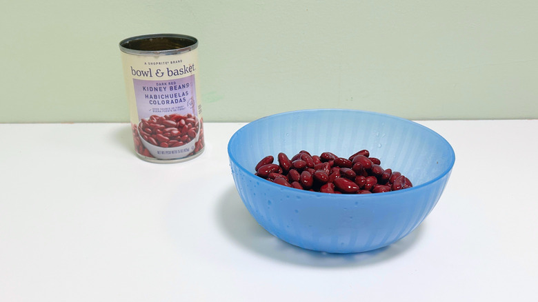A can of Bowl and Basket Dark Red Kidney Beans next to a blue bowl of kidney beans