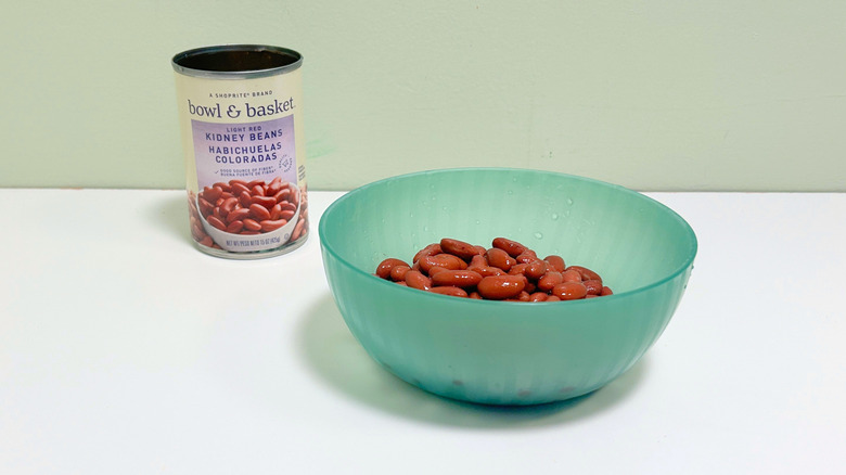 A can of Bowl and Basket Light Red Kidney Beans next to a green bowl of kidney beans