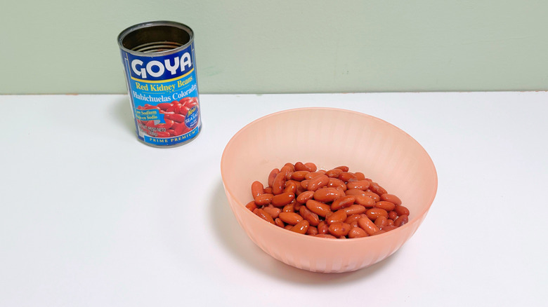 A can of Goya Red Kidney Beans next to a pink bowl of kidney beans