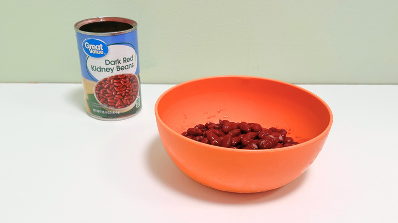 A can of Great Value Dark Red Kidney Beans next to an orange bowl of kidney beans