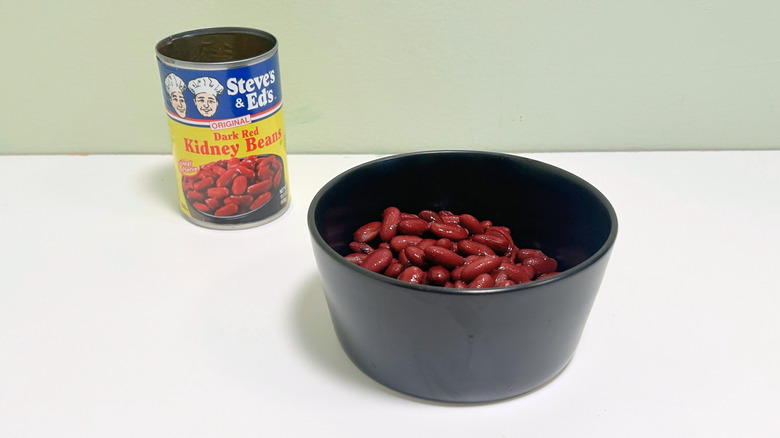 A can of Steve's and Ed's Original Dark Red Kidney Beans next to a black bowl of kidney beans