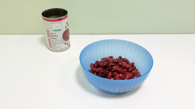A can of Wholesome Pantry Organic Dark Red Kidney Beans next to a blue bowl of kidney beans