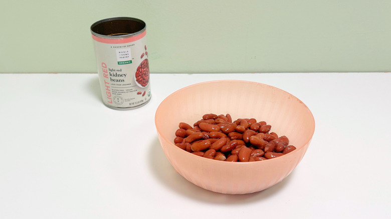 A can of Wholesome Pantry Organic Light Red Kidney Beans next to a pink bowl of kidney beans