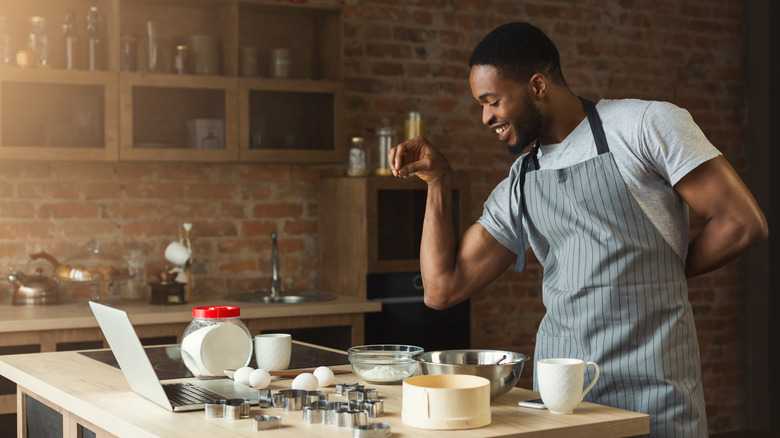 man seasoning food in kitchen