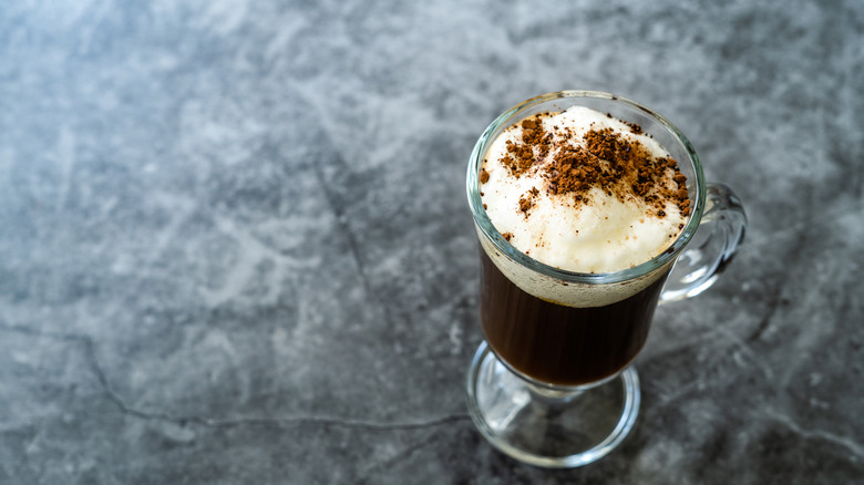 A mug of amaretto coffee on grey background