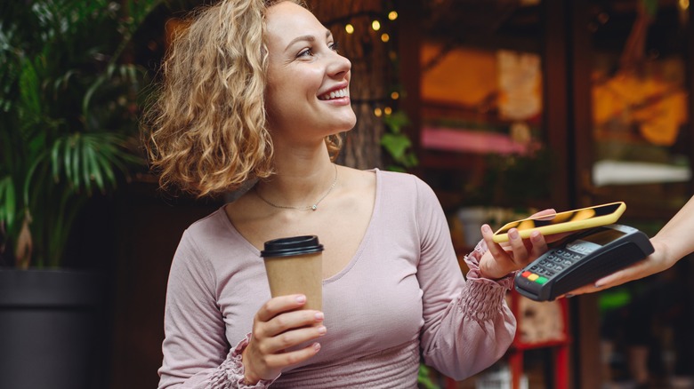 Woman smiling using coffee rewards