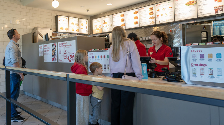 A Chick-fil-A employee serves customers in a restaurant