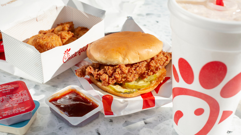A Chick-fil-A sandwich with nuggets and dips