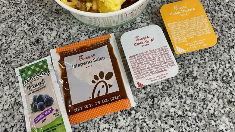 Chick-fil-A sauce sachets and packets on a granite table