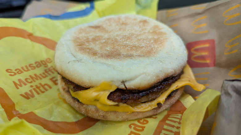 A close-up of a McDonald's Sausage McMuffin on branded paper