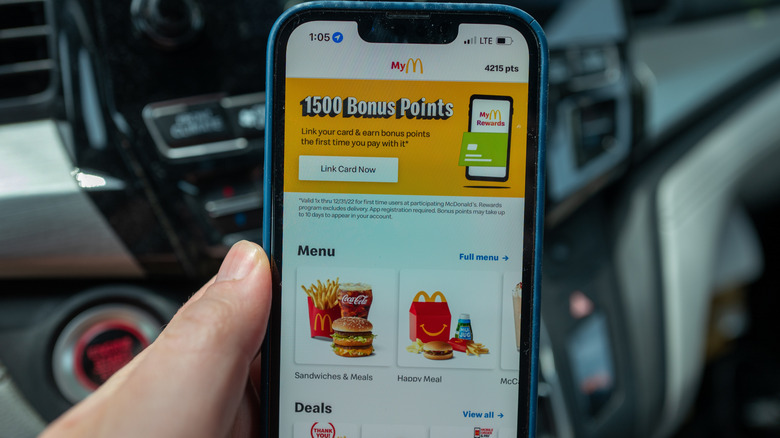 A phone displays the McDonald's app, with "1500 Bonus Points" at the top of the screen and menu items below