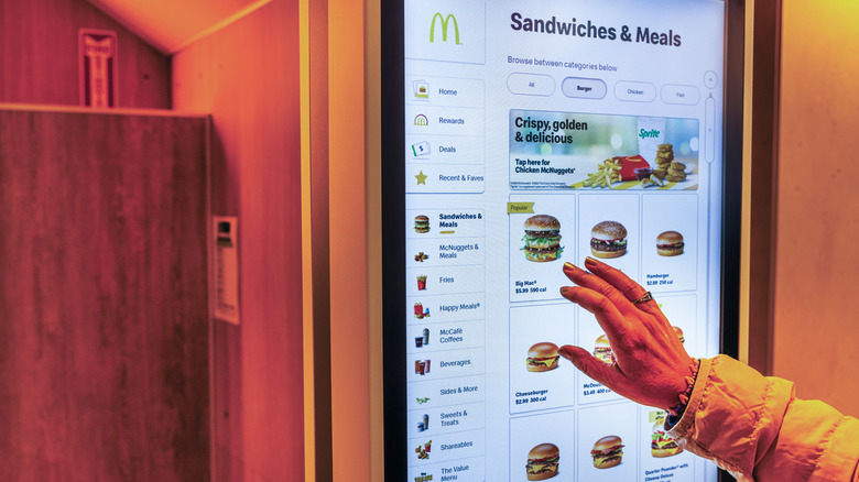 A person uses a McDonald's kiosk to order food