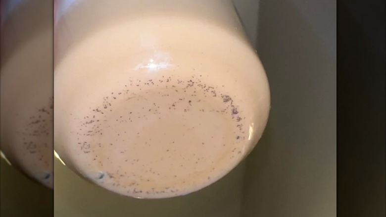 A cup of Nespresso coffee, with coffee grounds in the bottom
