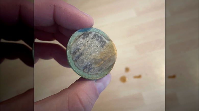 A hand holds a Nespresso pod