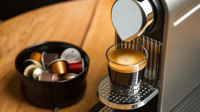 A Nespresso machine with a freshly poured cup of espresso