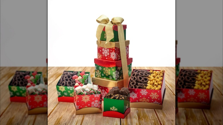 An assortment of shiny gold, red, and green gift boxes with various candies and treats inside