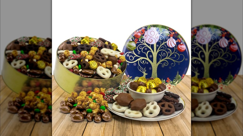 A large golden tin filled with assorted sweets and treats, with a Christmas-themed lid