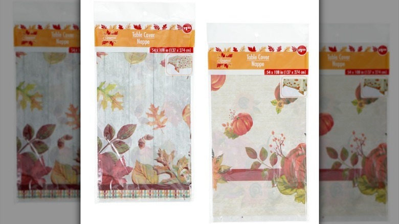 Two table cover options on a white background, one with leaves, one with pumpkins.