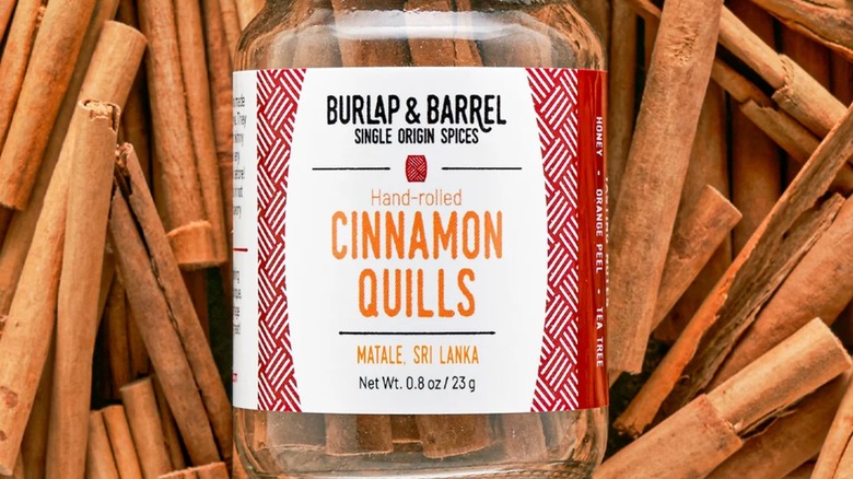Burlap & Barrel jar of cinnamon atop cinnamon bark