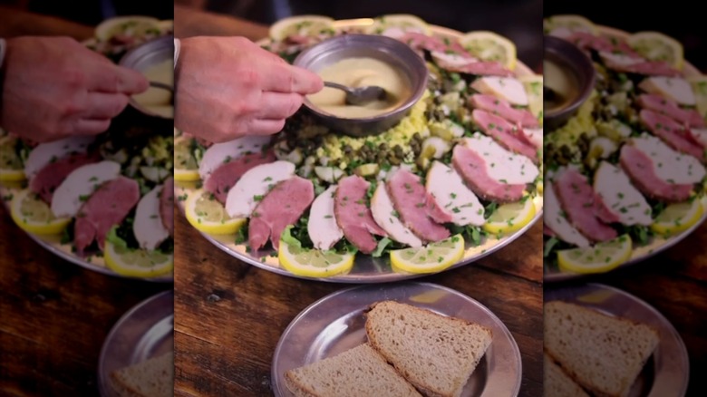 A hand serving sauce from a salamagundi salad plate