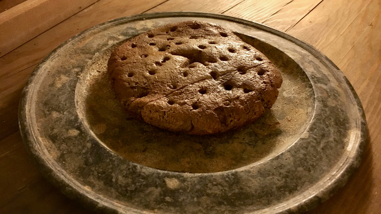 A hardtack biscuit on an earthen plate