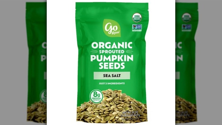 Bag of pumpkin seeds on white background