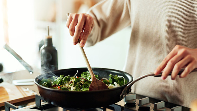 Person cooking meal in pan