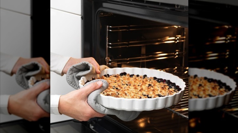 Hand grabbing pie in VARDAGEN pie plate from oven