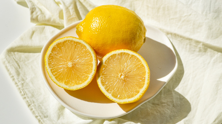 Whole and sliced lemons on a plate