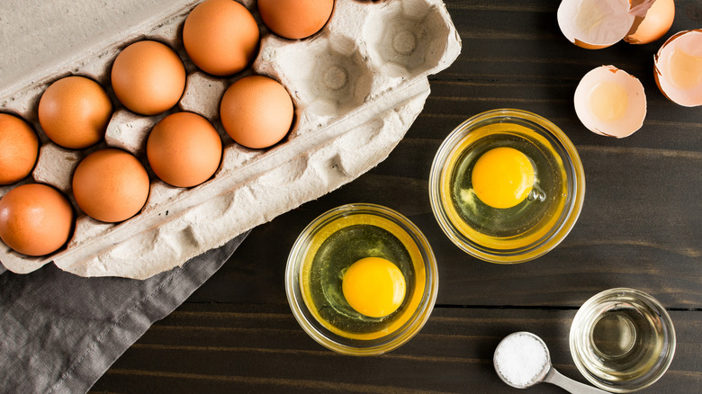 Whole and cracked eggs on a wooden table