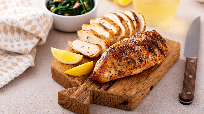 Grilled chicken breasts on a wooden board