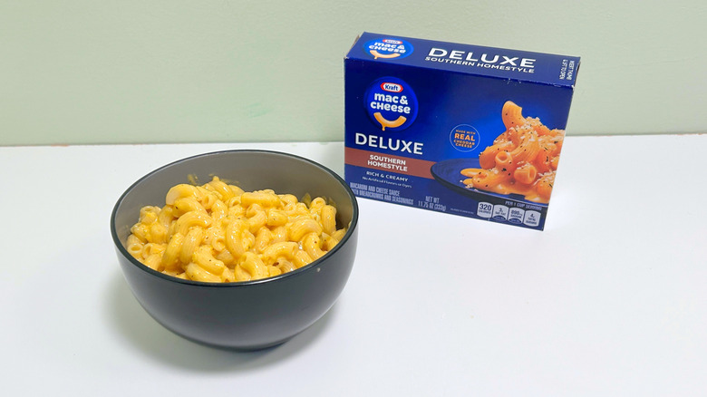 A box of Kraft Deluxe Southern Homestyle Mac and Cheese next to a bowl of mac and cheese